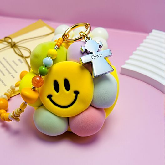 Close-up of smiley sunflower plush bag charm with pastel petals, gold clasp and beaded strap—cute women/girls bag accessory (bagcharms)