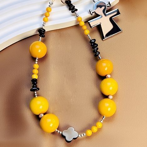 Close-up of yellow agate beads and red garnet chips on crochet sunflower bag charm with gold clasp and name tag (bagcharms)