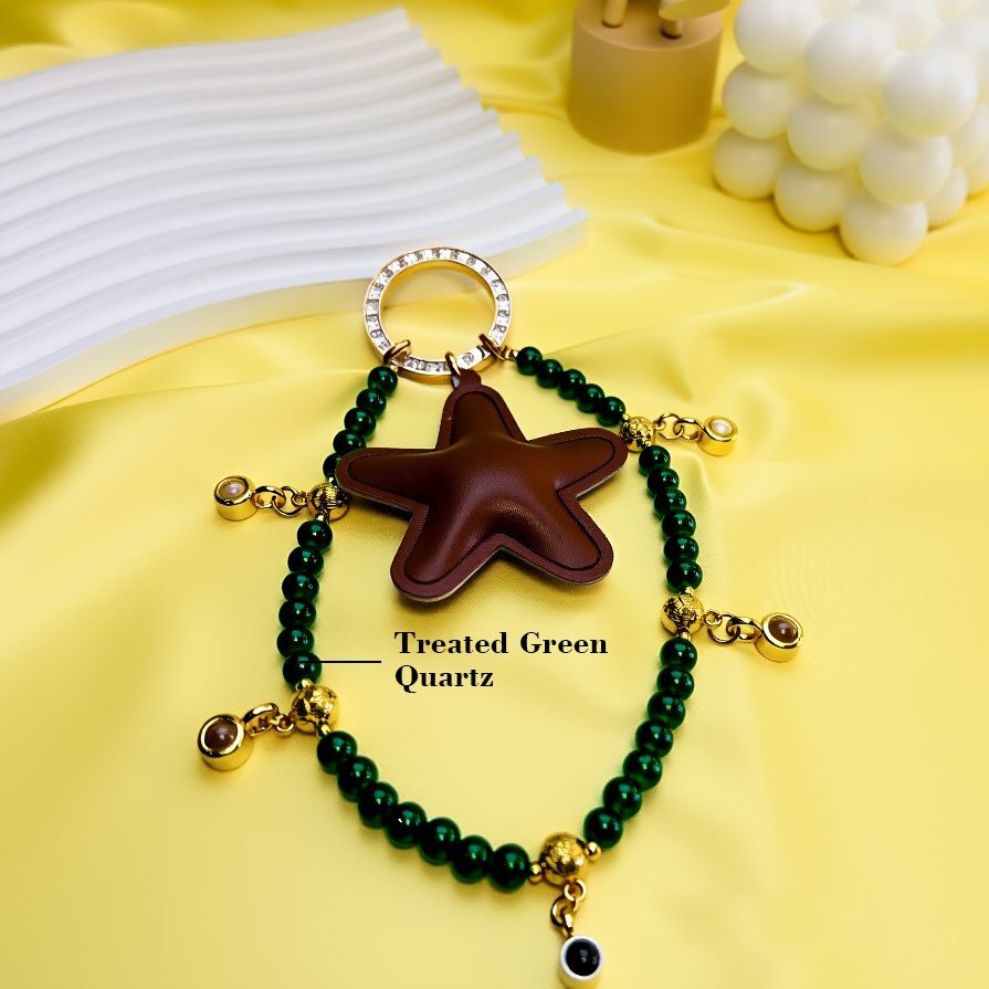 Close-up of family tree bag charm materials with treated green quartz beads, leather star pendant, gold-plated beads, handcrafted keychain accessory