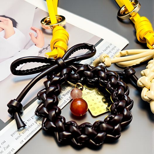 Dark leather wreath bag charm with bow, red agate & rose quartz beads and gold calendar tag on yellow strap (bagcharms)