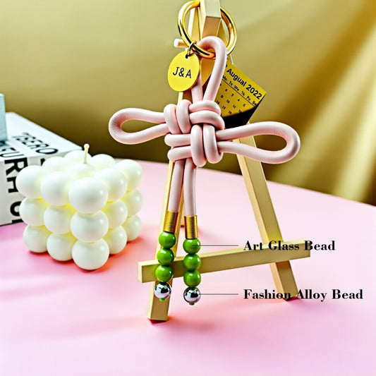 Handwoven leather love knot bag pendant with art glass beads and fashion alloy beads, custom couple gift keychain, personalized romantic accessory, love and connection collection, stylish handmade bag charm