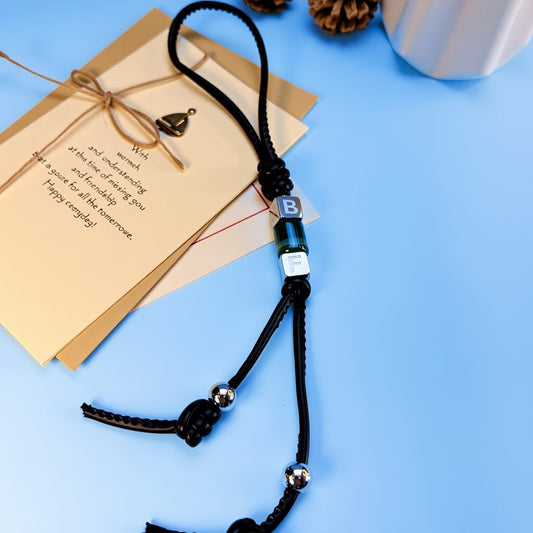 Custom letter bead bag charm showing full length cord with metal end beads and malachite energy tube