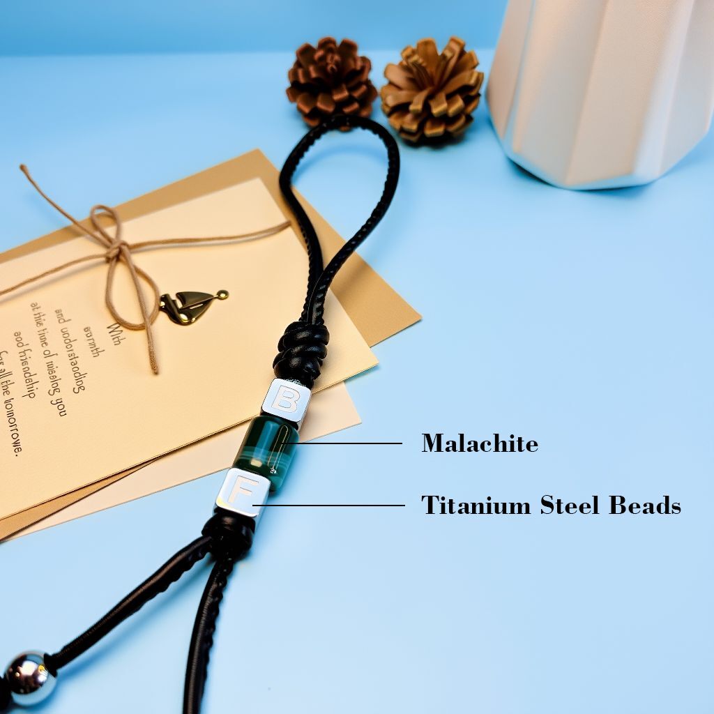 Close view of malachite energy bead and initial cubes on braided cord—personalized bag charm