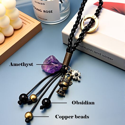 Close-up of amethyst, obsidian and copper beads with antique bronze totem pendant on travel souvenir bag charm (bagcharms)