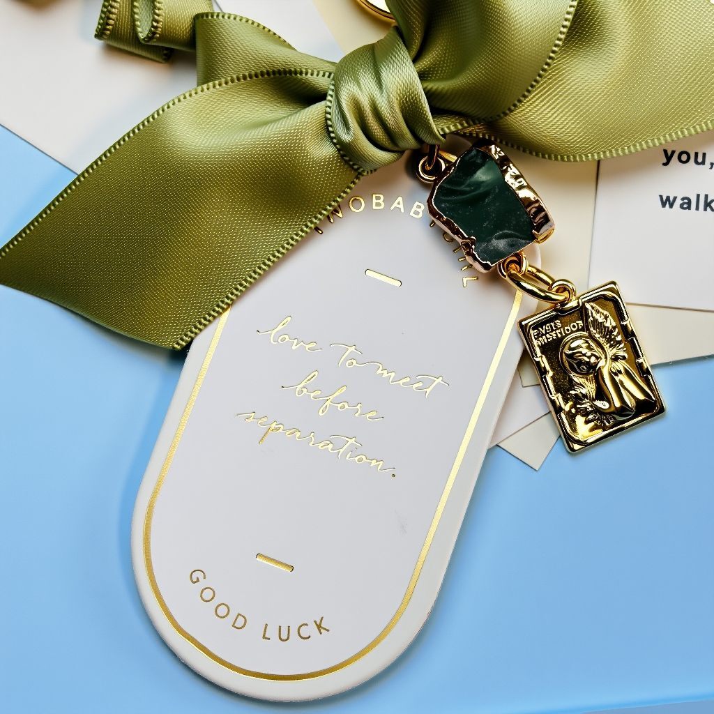 Close-up of green ribbon and gold charm detail on eternal flower lucky bag charm, personalized accessory for bags, handcrafted good luck charm