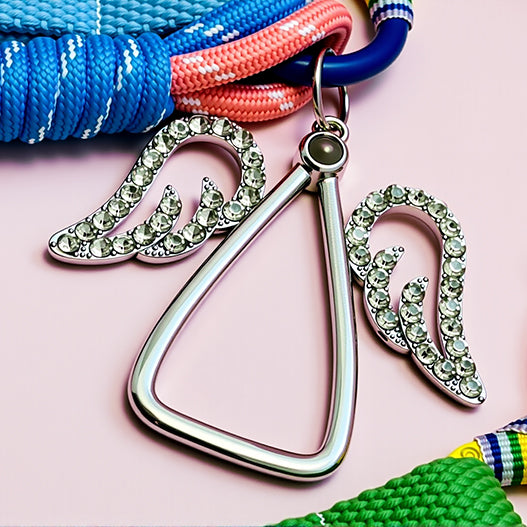 Rhinestone angel wing centerpiece and alloy triangle ring on personalized children’s backpack charm.