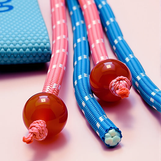 Detail of paracord tassel ends with glossy red agate beads on custom name anti-loss bag charm for kids.