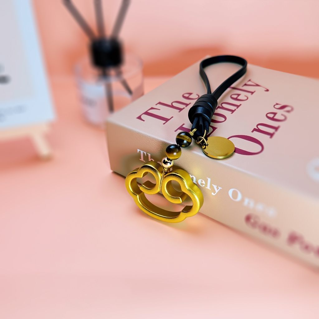 Close-up of brass lucky cloud bag charm with polished finish and intricate details, a personalized accessory symbolizing luck and protection