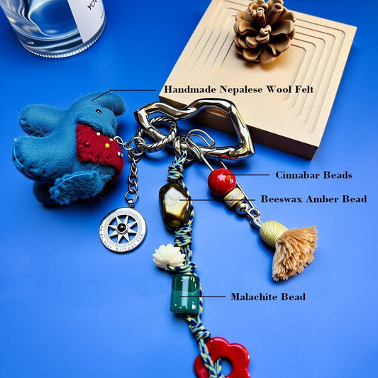 Full view of lucky elephant bag charm with heart-shaped clip, compass charm, tassel and mixed energy stones.