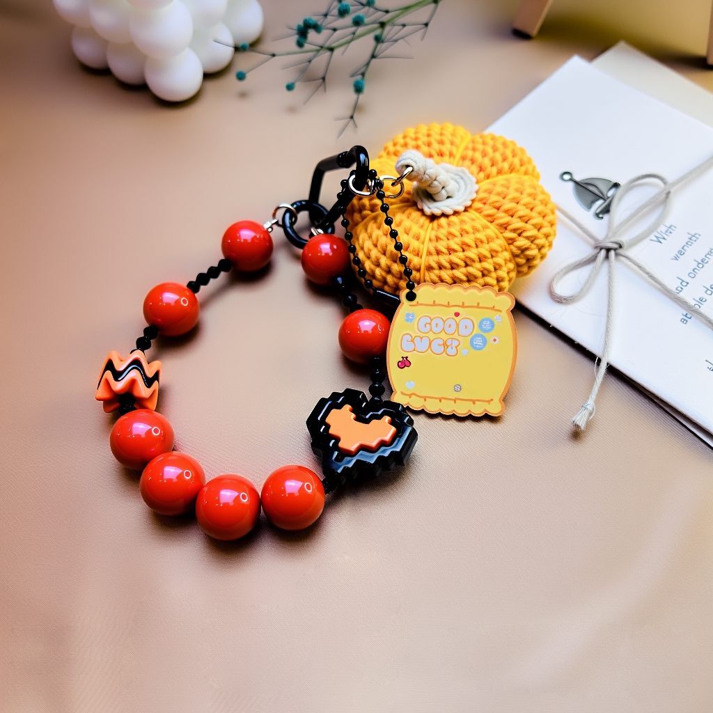 Spooky-cute pumpkin beaded bag charm—Nanhong agate, crystal glass, acrylic heart and black clasp (bagcharms)