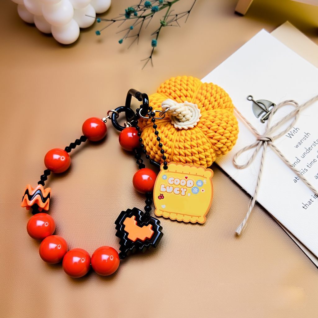Handmade pumpkin bag charm with beaded strap and “Good Luck” tag—cute Halloween/fall accessory (bagcharms)